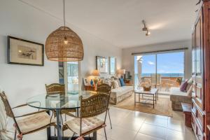 a living room with a glass table and chairs at Jávea Beachfront Penthouse in Platja de l'Arenal