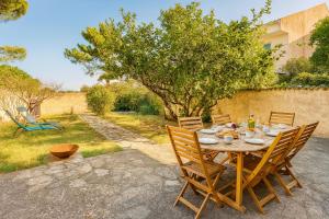 einen Tisch mit Stühlen und Essen auf dem Hof in der Unterkunft Villa Caline, 4 chambres, lotissement calme et proche mer in Lucciana