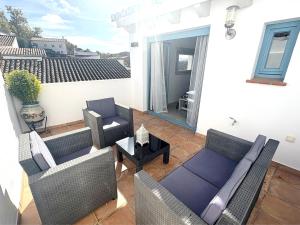 a patio with chairs and a couch and a table at XXIX Casa El Balcón in Cortes de la Frontera