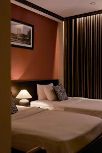 ein Hotelzimmer mit zwei Betten und einer Lampe in der Unterkunft The One Premium Hotel Spa in Ho-Chi-Minh-Stadt