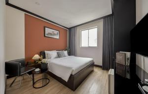 a hotel room with a bed and a television at The One Premium Hotel - 1 Minute to Ben Thanh Market in Ho Chi Minh City