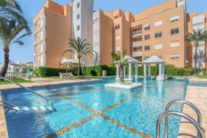 a swimming pool in front of a building at Jávea Beachfront Penthouse in Platja de l'Arenal