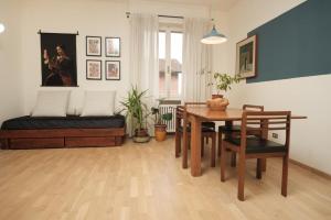 a living room with a table and a bed at Tra le case di Reggio - Pisacane in Reggio Emilia