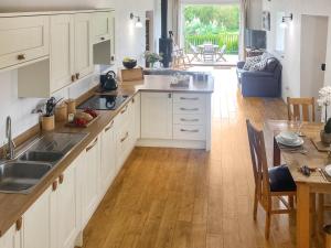 ポーツカソにあるSwallowsの白いキャビネットと木製の床を備えたキッチン