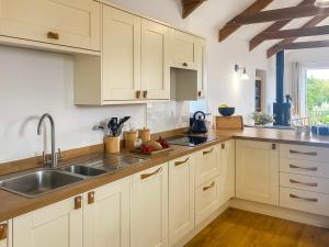 ポーツカソにあるSwallowsの白いキャビネットとシンクのあるキッチン