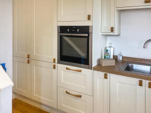 ポーツカソにあるSwallowsのキッチン(白いキャビネット、黒いオーブン付)