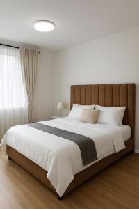 a bedroom with a large bed with white sheets and pillows at Book n Breeze in Nairobi