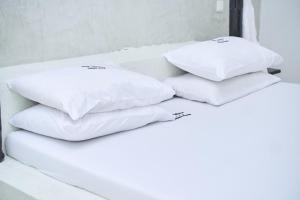 three white pillows sitting on top of a bed at White Villa Paparemo Village in Watamu +3 photos