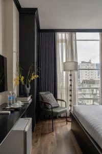 ein Schlafzimmer mit einem Bett, einem Schreibtisch und einem Stuhl in der Unterkunft The One Premium Hotel Spa in Ho-Chi-Minh-Stadt