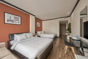 a hotel room with two beds and a television at The One Premium Hotel - 1 Minute to Ben Thanh Market in Ho Chi Minh City