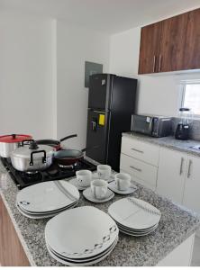 a kitchen counter with plates and cups and a stove at Welcome to your perfect Manta Coast getaway in Manta