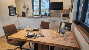 a kitchen with a wooden table with chairs and a tableasteryasteryasteryasteryastery at Wallys Auszeit in Grub am Forst