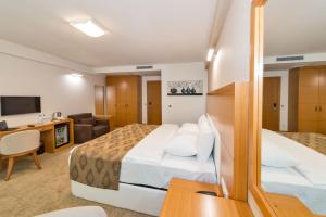 una camera d'albergo con due letti e una scrivania di PALMIYE hotel SUITES a Istanbul