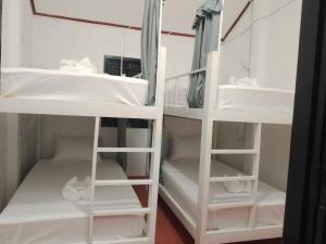 NongkhiawThe Sun Backpackers Hostel的一间设有白色双层床的房间