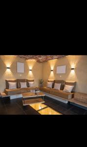 a living room with couches and a table and lights at Le Marzelheide 1 in Lontzen