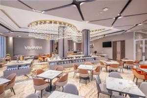 a rendering of a restaurant with tables and chairs at Wahid Prime Hotel Salatiga in Salatiga