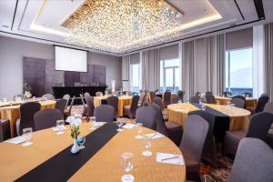 a conference room with tables and chairs and a projection screen at Wahid Prime Hotel Salatiga in Salatiga