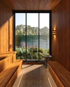 a room with a large window with a view of the water at Fredvang Lodge, Lofoten in Hovdan
