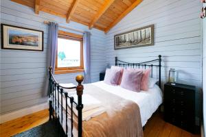 a bedroom with a bed with white sheets and pink pillows at Beautiful 3-Bed Luxury Private Lodge in York in York