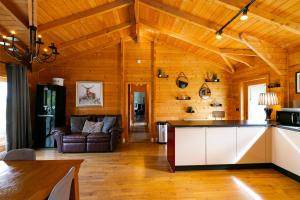 a kitchen and living room with wooden walls at Beautiful 3-Bed Luxury Private Lodge in York in York