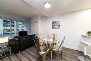 ein Wohnzimmer mit einer Couch und einem Glastisch in der Unterkunft Corporate Stays Tate 1 Bedroom in Vancouver