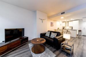 ein Wohnzimmer mit einer Couch, einem Fernseher und einem Tisch in der Unterkunft Corporate Stays Tate 1 Bedroom in Vancouver