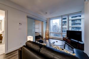 ein Wohnzimmer mit Couch und großem Fenster in der Unterkunft Corporate Stays Tate 1 Bedroom in Vancouver + 7 Fotos