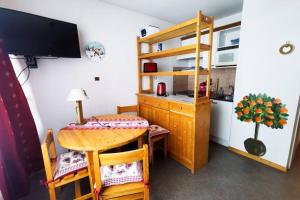 Habitación pequeña con mesa y cocina en Family apartment at the foot of the slopes, en Les Déserts