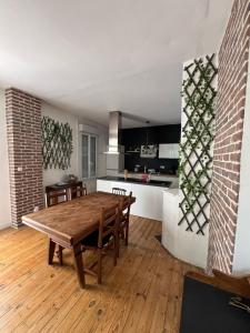 eine Küche und ein Esszimmer mit einem Holztisch in der Unterkunft L Atypique Briviste - Villa Montyon in Brive-la-Gaillarde