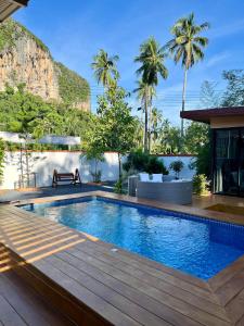 a swimming pool with a wooden deck next to a building at Cocoloco Pool Villa Ao nang in Ban Khlong Son