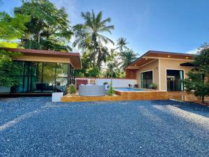 a house with a hot tub in front of it at Cocoloco Pool Villa Ao nang in Ban Khlong Son