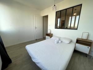 a white bedroom with a bed and a mirror at Leo Lagrange in Champforgeuil