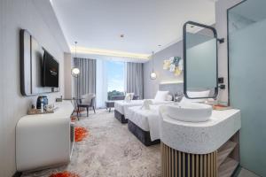 a hotel room with two beds and a sink at Wahid Prime Hotel Salatiga in Salatiga +8 photos