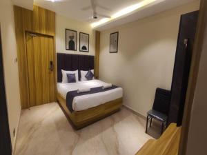 a bedroom with a king sized bed and a chair at Sivashree Residency in Tiruvannāmalai
