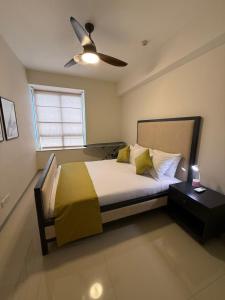 a bedroom with a bed with a ceiling fan at Gems Havelock Apartment in Colombo