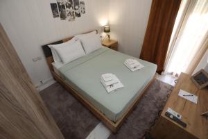 a small bedroom with a large bed with two dishes on it at LA Larissa Luxury Apartments Trekke in Larisa