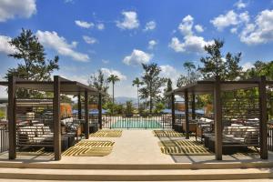 a pool at a resort with chairs and a pavilion at Mövenpick Kigali in Kigali +5 photos