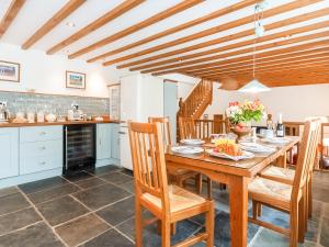 a kitchen with a wooden table and chairs at Ty Menyn in Mathry +7 photos
