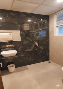 a bathroom with a sink and a black wall at Raghunath Jammu in Jammu