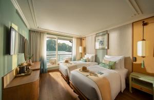 a hotel room with two beds and a window at Bhaya Soul Cruise in Ha Long