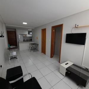 a living room with a tv on a wall at Apartamento em João Pessoa in João Pessoa