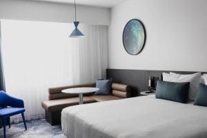 Un dormitorio con una cama, una silla y una mesa. en Bayside Geelong Hotel & Apartments, an Ascend Collection Hotel, en Geelong