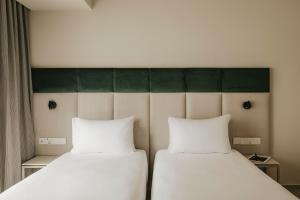 two beds sitting next to each other in a room at Regional Hotel by NEU Collective in Il-Gżira