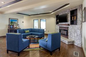 a living room with a blue couch and a stone fireplace at Comfort Inn & Suites Sterling in Sterling