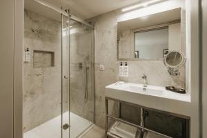 a bathroom with a sink and a shower at Regional Hotel by NEU Collective in Il-Gżira