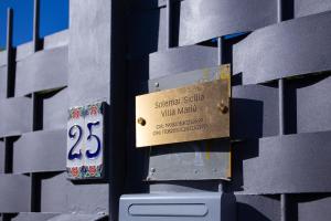 a sign on the side of a building at Solemar Sicilia - Villa Mariù in Palermo