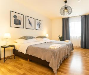 a bedroom with a large bed and a chandelier at Airport Messe Hotel in Düsseldorf