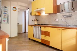 a kitchen with yellow cabinets and a sink at Solemar Sicilia - Villa Mariù in Palermo