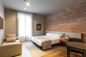a bedroom with a bed and a brick wall at Colectia Stays Pau Claris in Barcelona +83 photos