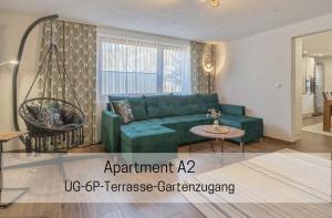 ザンクト・ブラージエンにあるFerienhaus Albmatte-Naturidyll am Fluss-Novemberaktion-Sauna inklusiveの緑のソファとテーブルのあるリビングルーム